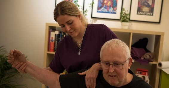 Amy O'Halloran assessing a patient's arm and shoulder movement at Silsden Osteopathy